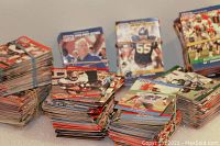 Stacks of NFL football cards, showing multiple piles organized on a table, mostly loose cards with colorful player photos.