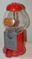 Photo of a metal Jelly Belly candy dispenser with clear globe and red metal base about 9.5 inches tall