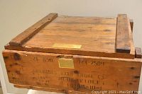 Top and side view showing wooden slat reinforcements, metal hinges, military stencil marking with grenade details.