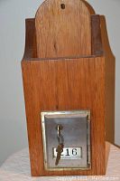 Front view of custom wooden postal storage box showing wood grain, metal lockable door with key and number 316 plate
