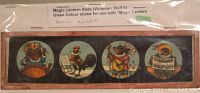 Photo showing a close-up of the Musical Animals Victorian glass slide with four circular color illustrations featuring anthropomorphic animals playing instruments.