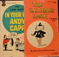 Two vintage cartoon paperback books: The Wizard's Back (Wizard of Id) and Andy Capp 7th Larf Riot edition.
