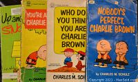 Close-up of four Peanuts books with colorful covers featuring Charlie Brown and friends.