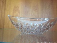 Side and angled view of clear oval crystal serving bowl showing diamond-cut textured pattern on sides and smooth rim.