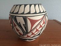 Front and side view of a round pottery bowl featuring traditional Jemez Pueblo geometric motifs in black and red on clay.