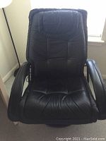 Front view of black leather swivel arm chair showing padded seat, backrest, and armrests.