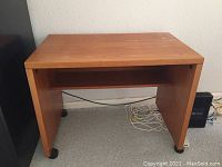 Front view of teak printer stand showing main surface and side panels with casters.