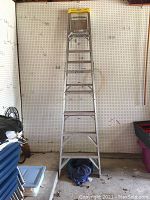 Front view of the 8-foot aluminum ladder showing the full height and structure in a garage setting.
