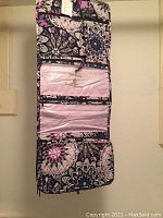 Photo of the travel kit unfolded showing clear plastic compartments and quilted patterned fabric.