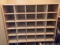 Full front view of the white wooden cube storage unit showing 25 square compartments arranged in 5x5 grid.