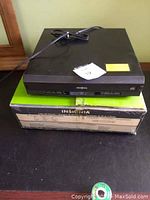 Front view of Insignia 5 disc CD player on its original box with power cord.
