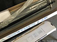 Photo showing partially opened boxes with black metal pickets inside, boxed with Fortress branding visible on the box exterior.