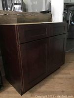 Dark wood bathroom vanity base cabinet assembled showing front with two drawers on top and two cabinet doors below.