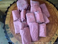 Beef package with 17 individually wrapped portions of assorted steaks, burgers, roasts, stew beef, and sandwich steak laid out on a wooden table.