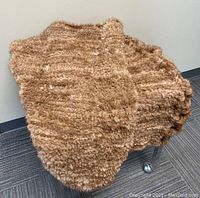 Brown mink fur knit throw draped on chair