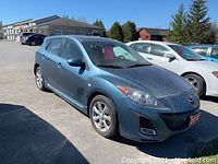Front three-quarter view of blue hatchback showing alloy wheel and headlight