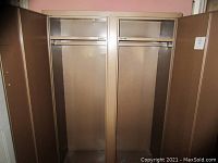 Photo of the open metal clothing cabinet showing two large compartments each with a hanging rod inside.