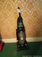 Photo of the upright Bissell Helix System vacuum cleaner with transparent dirt container and control labels