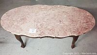Top view of the oval pink marble surface of the Victorian style coffee table.