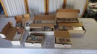 Multiple open cardboard boxes filled with unsorted sports trading cards