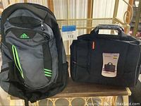 Two bags shown side by side: Adidas backpack with green accent logo and new black laptop computer case with original tag attached
