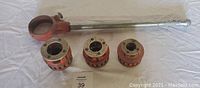 Hand thread set including a long 27 inch Ridgid handle and three dies sized 1 1/4, 1, and 3/4 inch.