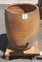 Full view of the large terracotta pot showing its size and shape on a dolly.