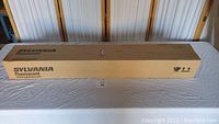 Closed long rectangular box labeled Sylvania Fluorescent containing bulbs.