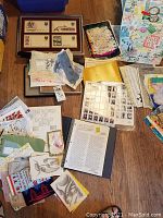 Overview of laid out mail art pieces, artwork sheets, book, postcards and binders