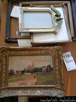 Overview of oil painting in gilt frame and four empty frames on table