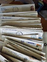 A collection of used postcards with stamps and cancellation marks, stacked together.