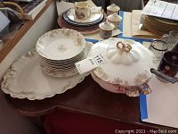 Overall view of Countess by Haviland Limoges china set including luncheon plate, soup bowls, tureen with lid, and oval platter, arranged on a table.