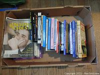 Top view of a box filled with various chess books lying horizontally.