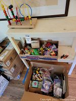 Wooden bead maze toy on white shelf with box of toys below