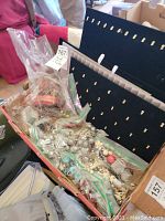 Overview of craft supplies including bags of beads, wires, and jewelry display boards.