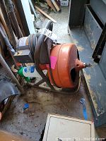 Full view of General's Mini Rooter showing orange coiled cable drum and black motor housing.