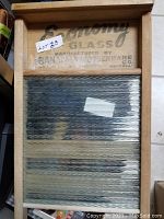 Vintage Economy Glass washboard with wooden frame and embossed manufacturer label at the top, ribbed glass scrubbing surface wrapped in plastic.