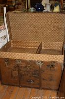 Large vintage trunk, open showing original fitted tray and interior patterned fabric lining.