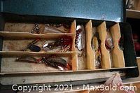 Open tackle box showing organized compartments with assorted vintage fishing lures and hooks