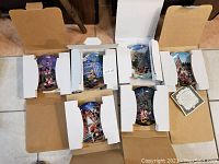 Five Disney collector plates in original white cardboard boxes arranged for photo, showing front illustrations and packaging