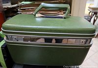 Closed view of the apple green vintage Samsonite make-up case showing exterior and handle.