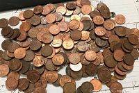 Loose pile of copper colored U.S. pennies on a white background with some numerical markings near the edges.