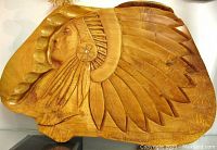 Full view of the carved maple wood block depicting an Indigenous chief in detailed feathered headdress, signed at bottom.