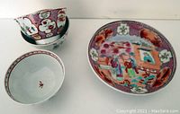 Photo of the entire lot showing three teacups and one plate with colorful Famille Rose designs.