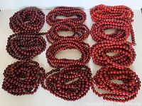 All 11 wooden bead garlands arranged in groups of color and bead size.