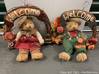 Front view of two wicker fall wreaths with teddy bears wearing seasonal clothes, each with 'Welcome' burlap sign above them.