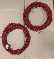 Two red grapevine wreaths with glitter, each about 17 inches wide, displayed on the floor.