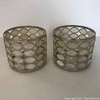 Photo of two metal candle holders with oval shell insets, showing overall design and shape