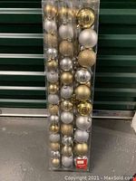 Full set of 74 shatter-proof holiday trim ornaments in gold, silver, and white colors, assorted shiny, matte, and glitter finishes in original packaging.