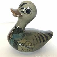 Ceramic duck side view showing hand-painted floral details and glossy finish.